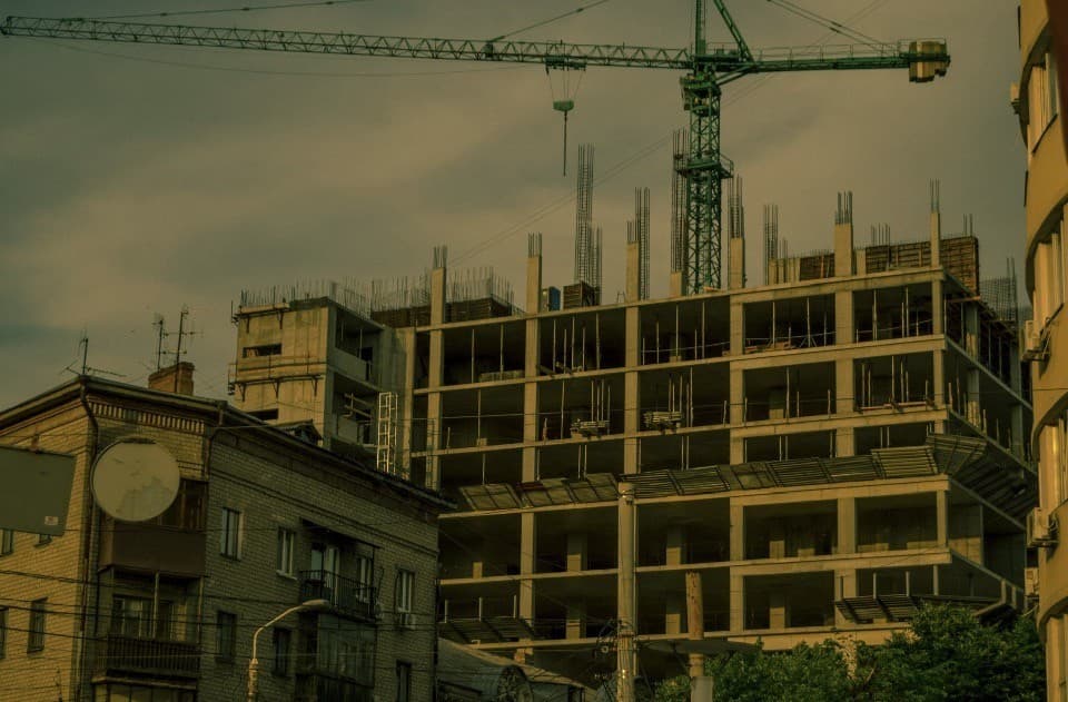 Concrete high-rise frame with green tower crane